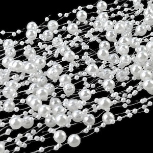 May include: White pearl garland with a delicate wire mesh design. The garland is made of small, round pearls that are strung together on a thin wire. The wire is woven into a mesh pattern, creating a delicate and elegant look.