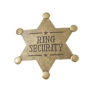 Puede incluir: Una insignia en forma de estrella de seis puntas con un acabado dorado antiguo desgastado. El centro presenta el texto RING SECURITY en letras oscuras y negritas, flanqueado por dos líneas horizontales y estrellas pequeñas.
