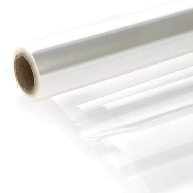 K&ouml;nnte beinhalten: Eine Rolle durchsichtiges Cellophan-Verpackungspapier. Das Papier ist aufgerollt und das Ende der Rolle ist sichtbar.