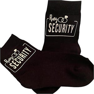 May include: A pair of black socks with white text that reads "Ring Security" and a graphic of two interlocking rings.
