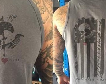 Może przedstawiać: Szara, bezrękawowa koszulka z nadrukiem czaszki i skrzyżowanych kości na przodzie. Nadruk zawiera tekst "Death is just a battle away". Z tyłu koszulka ma nadrukowaną przetartą flagę amerykańską z tekstem "Old Dread Sea" u góry i "XXVII - XVII" na dole.