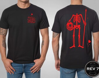 Może przedstawiać: Czarny t-shirt z czerwoną grafiką szkieletu nurka trzymającego włócznię i hełm do nurkowania na plecach. Przód ma małą czerwoną grafikę. Koszulka ma okrągły dekolt i krótkie rękawy.