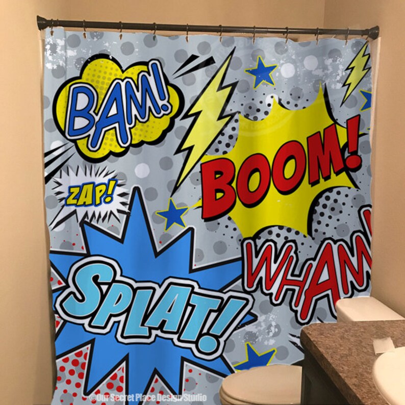 May include: A shower curtain with a comic book theme. The curtain features a gray background with colorful speech bubbles that say "BAM!", "ZAP!", "BOOM!" and "SPLAT!" The speech bubbles are surrounded by yellow lightning bolts, red and blue stars, and black and white polka dots.