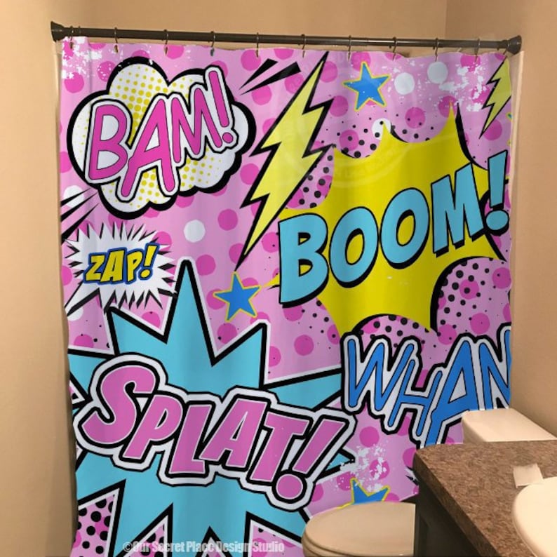 May include: A pink shower curtain with a comic book theme. The curtain features colorful words like "BAM!" "BOOM!" "WHAN!" and "SPLAT!" in a retro style.