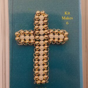 Puede incluir: Un kit para hacer seis cruces grandes de alambre de cuentas doradas y blancas. El kit hace cruces que miden 4,4 cm por 5,7 cm. El kit es de The Rainbow Collection.