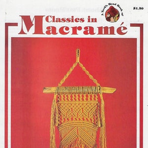 May include: A vintage book cover titled "Classics in Macramé" features a handmade macramé wall hanging in shades of yellow and beige. The background is a solid red, with a white border. The book cover also includes a small illustration.