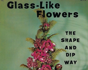 May include: A vintage craft book cover featuring a pink and green floral arrangement in a clear glass vase. The title is "Glass-Like Flowers" and the subtitle is "The Shape and Dip Way". The book is titled "Handicrafts For Fun".