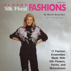 May include: A woman wearing a black turtleneck sweater with a floral design made with silk flowers, paints, and rhinestones. She is also wearing black pants with a similar floral design on the leg. The text on the cover reads "#8546 Plaid Silk Floral Fashions By Marion Brizendine Creator of "Silk Flower Sweats"" 17 Fashion Ensembles Made With Silk Flowers, Paints, and Rhinestones"