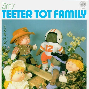 Könnte beinhalten: Ein Set mit fünf Cabbage Patch Kids Puppen, darunter ein Mädchen in einem weißen Kleid, ein Junge in einem Cowboy-Outfit, ein Mädchen in einem lila Kleid, ein Junge in einer Fußballuniform und ein Junge in Tarnkleidung. Die Puppen spielen auf einer Holzwippe.