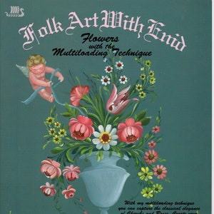 May include: A book cover with a teal background and the title "Folk Art With Enid" in pink and black lettering. The subtitle is "Flowers with the Multiloading Technique". The cover features a painting of a vase of flowers with a cherub holding a ribbon.