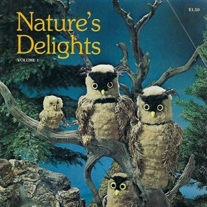 May include: A vintage book cover featuring a nature-themed illustration of four owls perched on a tree branch. The book title is "Nature's Delights" with the subtitle "Volume I". The book cover is a light blue color with a brown tree branch and green foliage.