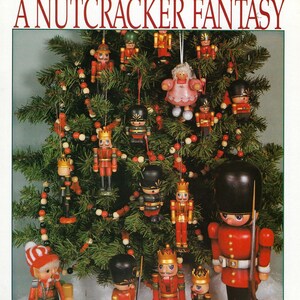 Pode incluir: Uma árvore de Natal decorada com enfeites de quebra-nozes e guirlandas de contas. Várias figuras de quebra-nozes estão na base da árvore. O texto "A Nutcracker Fantasy" está na parte superior da imagem.