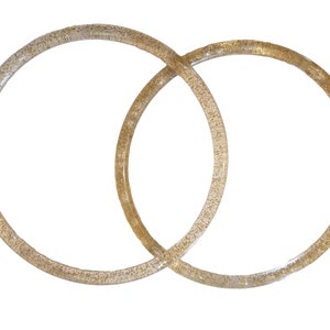 May include: Two interlocking gold-toned rings with a sparkly finish.