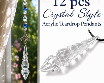 Op de afbeelding: Een set van 12 druppelvormige acrylhangers in kristalstijl. De hangers zijn transparant, gefacetteerd en puntig. Eén hanger hangt aan een zilverkleurige metalen ketting met blauwe en doorzichtige kralen, en een andere aan een zwart koord.