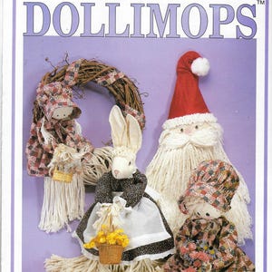 Puede incluir: Un patrón de artesanía para hacer cuatro adornos diferentes con forma de muñeca. Las muñecas son un conejito, un Papá Noel y dos niñas con gorros. Las muñecas están hechas de tela e hilo. El patrón se llama "Dollimops" y es de Zims Inc.
