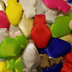 May include: A collection of colorful felt ornaments shaped like light bulbs. The ornaments are in various colors, including red, green, blue, yellow, gold, silver, and white.