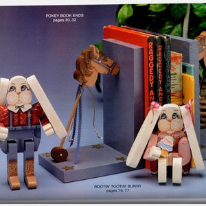 May include: Wooden bunny bookends and a horse-themed bookend with books. The bunny figures are painted with details like overalls and bows. The text "POKEY BOOK ENDS" and "ROOTIN' TOOTIN' BUNNY" are visible.