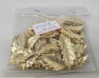 May include: A clear plastic bag containing 100 gold-colored metal leaf-shaped charms. A white rectangular label is attached to the front of the bag with the text #30076, 100 PCS, and MADE IN TAIWAN R.O.C. printed in black and red ink.