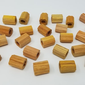 May include: A collection of wooden beads with a hexagonal shape and a hole in the center. The beads are various shades of brown and orange.