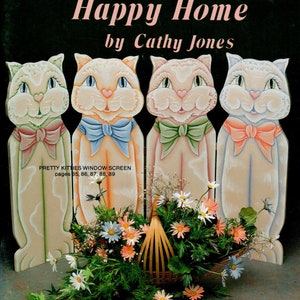 May include: A decorative window screen featuring four cat figures with bow ties, and a basket of flowers. The screen has the text "Happy Heart Happy Home by Cathy Jones" and "Susan Scheewe Presents".