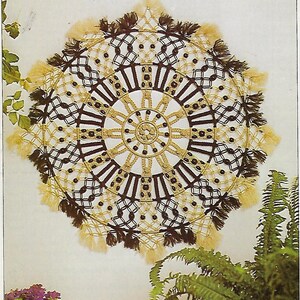 May include: A brown and beige macrame wall hanging with a circular design and fringe. The hanging is made with knotted cords and has a geometric pattern.