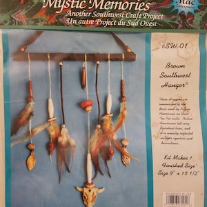 May include: A craft kit to make a brown southwest hanger, with a finished size of 9 inches by 15 and a half inches. The kit includes feathers, beads, and a wooden bull skull. The kit is reminiscent of Native American decor.