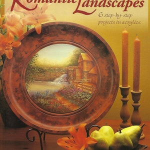 Könnte beinhalten: Ein Buch mit dem Titel "Painting Romantic Landscapes: 6 step-by-step projects in acrylics" von Sharon Buononato, CDA. Der Umschlag zeigt eine gemalte Landschaft auf einem Holzteller, im Vordergrund ein Stillleben mit Birnen und einer Lilie.