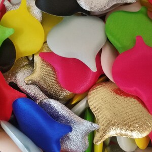 Può includere: Una collezione di forme di feltro colorate in varie dimensioni e trame, tra cui cuori, lacrime e altre forme astratte. Le forme sono realizzate con una varietà di materiali, tra cui feltro, raso e glitter.