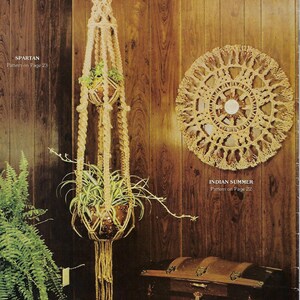 May include: Two macrame plant hangers against a brown wooden background. The plant hangers are made of natural rope and have a fringe design. The plant hangers are labelled "Spartan" and "Indian Summer" with their respective page numbers.