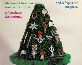 May include: A green macrame Christmas tree with white and red ornaments, a snowman, and a gift package. The text "Judy Palmer's Macrame Tree-Time Favorites" is at the top of the image. The text "Macrame Christmas ornaments for tree, gift package decorations, and refrigerator magnets." is below the tree. The text "#7455 Plaid" is at the bottom of the image.