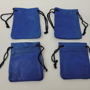 Puede incluir: Cuatro pequeñas bolsas de cordón azul con cordones negros. Las bolsas están hechas de un material suave y texturizado.