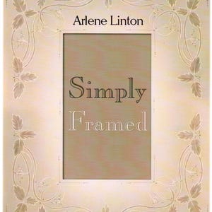 May include: A rectangular picture frame with a cream-colored border and a central opening. The frame is adorned with a delicate floral and leaf design. The text "Arlene Linton" and "Simply Framed" are visible.