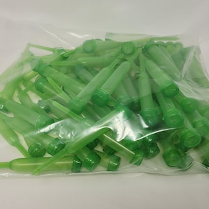 Puede incluir: Una bolsa de plástico transparente llena de numerosos soportes de agua florales verdes. Cada soporte tiene un cuerpo cilíndrico, una punta y una tapa. Estos soportes están diseñados para contener agua para flores frescas.