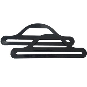 Pode incluir: Dois cabides de pl&aacute;stico preto projetados para pendurar medalhas ou fitas. Os cabides t&ecirc;m uma parte superior curva e uma parte inferior plana com duas linhas paralelas.