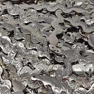 May include: A collection of silver-toned metal components, each featuring a long, wavy, snake-like shape with a central zigzag pattern and small circular loops at both ends for attachment, creating a reflective and textured metallic surface.