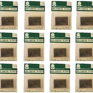 May include: Twelve packages of silver beading wire, each package labeled "Superior Quality Beading Wire" with a price of $1.49. The packages are made in Japan and are silver in color.