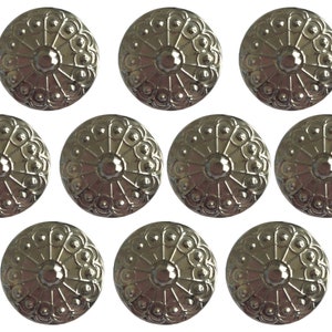 May include: Ten silver-toned metal buttons with a decorative design. Each button has a raised center with a circular pattern and a ring of smaller circles around the edge.