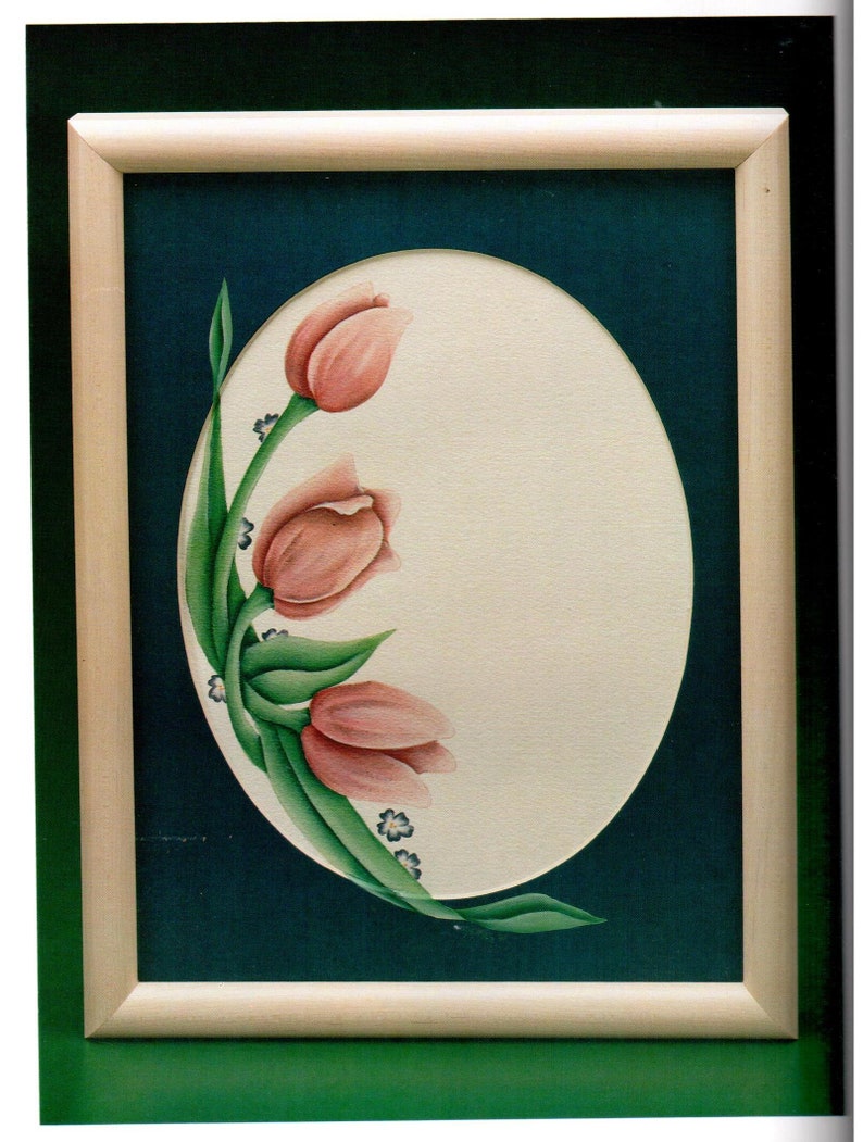 May include: A framed painting featuring three pink tulips with green leaves and small blue flowers. The tulips are arranged on a cream-colored oval against a dark teal background, enclosed in a light wood frame.