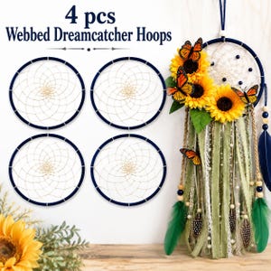 May include: Four circular dark blue dreamcatcher hoops with cream-colored woven webbing, accompanied by a fully decorated dreamcatcher featuring yellow sunflowers, orange monarch butterflies, green fabric ribbons, and dark blue feathers.