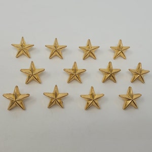 May include: Twelve gold-coloured five-pointed star-shaped metal embellishments.