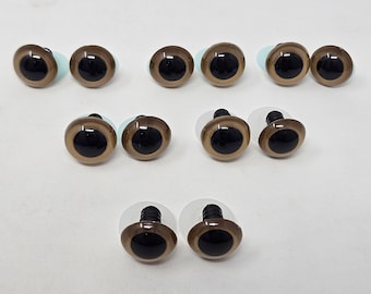 Peut inclure: Ensemble d'yeux de sécurité en plastique marron et noir pour l'artisanat. Les yeux ont une pupille noire brillante entourée d'un iris brun clair. Chaque œil est doté d'un support en plastique transparent et d'une tige filetée noire pour la fixation.