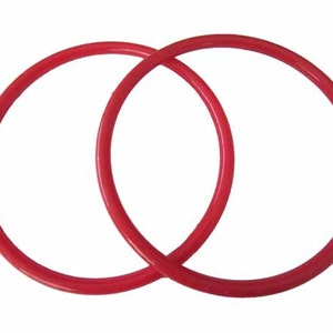 May include: Two red plastic rings, interlocked, with a smooth, glossy finish.