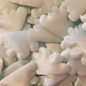 Puede incluir: Un montón de pétalos de flores de tela de satén azul claro con bordes festoneados.