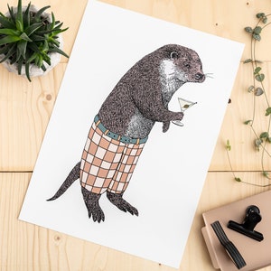 May include: A black and white illustration of an otter wearing plaid pants and holding a martini glass. The otter is standing on a white background.