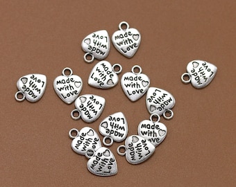 May include: Silver heart-shaped charms with the text "Made with Love" and "Love with a little arrow" printed on them.