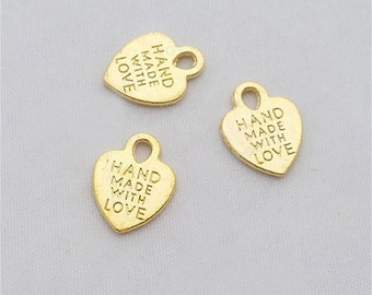 May include: Three gold heart-shaped charms with the text "HAND MADE WITH LOVE" engraved on each charm.