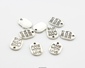 May include: Silver metal tags with the text "Made with Love" on them. The tags are oval shaped and have a hole at the top for attaching to a string or ribbon.