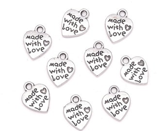 May include: Nine silver heart-shaped charms with the words "Made with Love" engraved on them. Each charm has a small loop at the top for attaching to jewelry or other crafts.