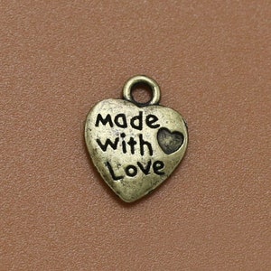 May include: A gold-toned heart-shaped charm with the words "Made with Love" and a small heart design.
