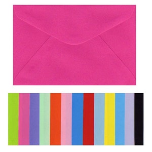 May include: A bright pink envelope with a white flap. The envelope is shown against a background of 12 colored paper strips in various shades of green, pink, purple, light green, orange, red, light blue, blue, red, light blue, yellow, blue, purple, and black.